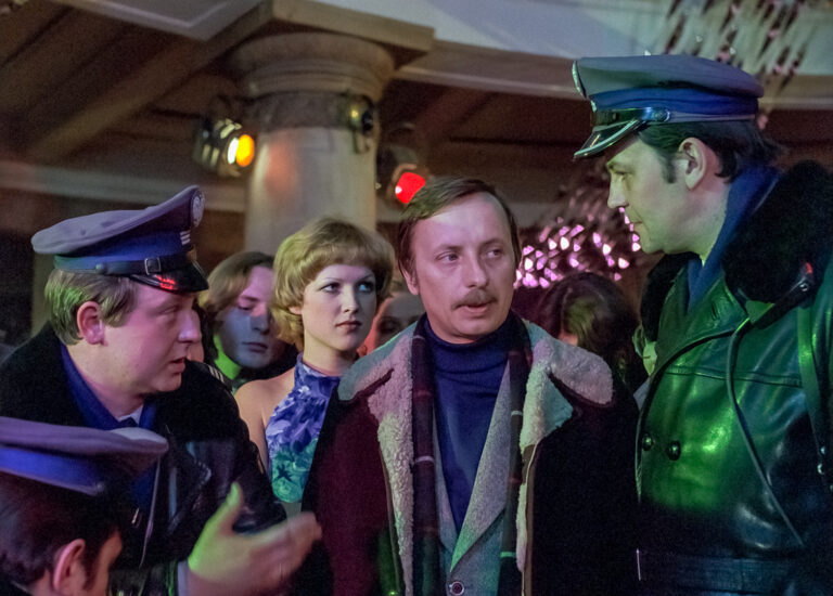 kadr z filmu ,,Brunet wieczorową porą" - przedstawiający grupę osób w tym dwóch policjantów na imprezie