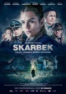 Plakat filmu „Skarbek”. Na tle zniszczonego miasta w ruinach stoi młoda kobieta w ciemnym płaszczu i beretce, z wyrazem twarzy pełnym determinacji. Wokół niej widoczni są mężczyźni w mundurach wojskowych, w tym oficer niemiecki w mundurze z odznakami. Na pierwszym planie, po lewej, znajduje się postać kobiety, której twarz jest wyraźnie widoczna, a reszta postaci jest nieco bardziej rozmyta. Nad nimi napis: „Prawdziwa historia SKARBEK. Polka. Legenda wśród szpiegów”. U dołu plakatu tytuł filmu: „SKARBEK” oraz informacja o dacie premiery: „W kinach od 3 października 2025”.
