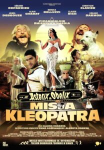 Plakat przedstawia grupę bohaterów filmu na tle pustynnego krajobrazu. W centrum znajduje się kobieta w białym stroju i nakryciu głowy, stojąca na tle dużego, jasnego okręgu. Po jej bokach widoczni są pozostali bohaterowie, wśród nich mężczyzna z jasnymi włosami i brodą, mężczyzna w egipskim stroju oraz postać w zbroi. Po prawej stronie znajduje się mężczyzna trzymający białego psa. W górnej części plakatu umieszczono nazwiska aktorów oraz napis „PIRAMIDALNIE ŚMIESZNA KOMEDIA”. W centralnej i dolnej części znajduje się tytuł „Asterix & Obelix: MISJA KLEOPATRA”. Na dole widnieją informacje o reżyserze, podstawie komiksowej oraz napis „WERSJA ODRESTAUROWANA 4K Z ORYGINALNYM POLSKIM DUBBINGIEM PONOWNIE W KINACH”.